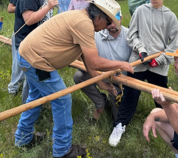 Volunteers raising the tipi at Arapaho Youth Camp